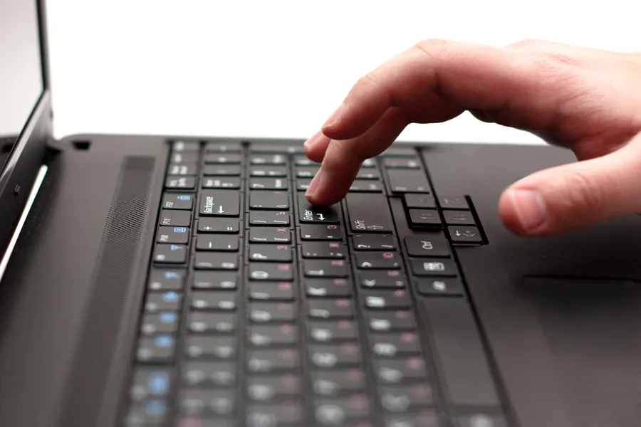 Nærbilde av tastatur og hånd på bærbar PC